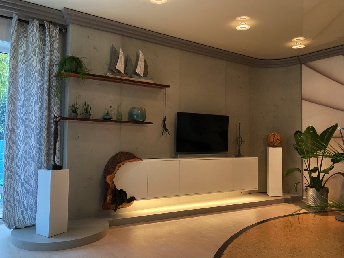 Wohnwand aus einer Imi-Betonwand mit eingeschobenem Hochglanz-Sideboard